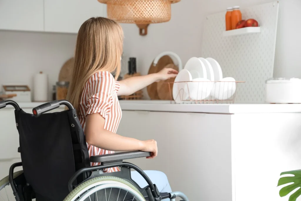 Disabled woman in wheelchair putting dishes away at home